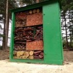 Photo of a green junction box that has been turned into an insect hotel