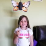 Photograph of 7 year old fan Jess who customised the silver-studded blue butterfly template to make a wonderful marsh fritillary butterfly!