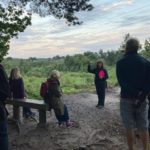 Photograph of Warden Nicky with a group at dusk.