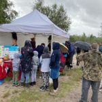 Crowds standing around a gazebo at Ockham Common.