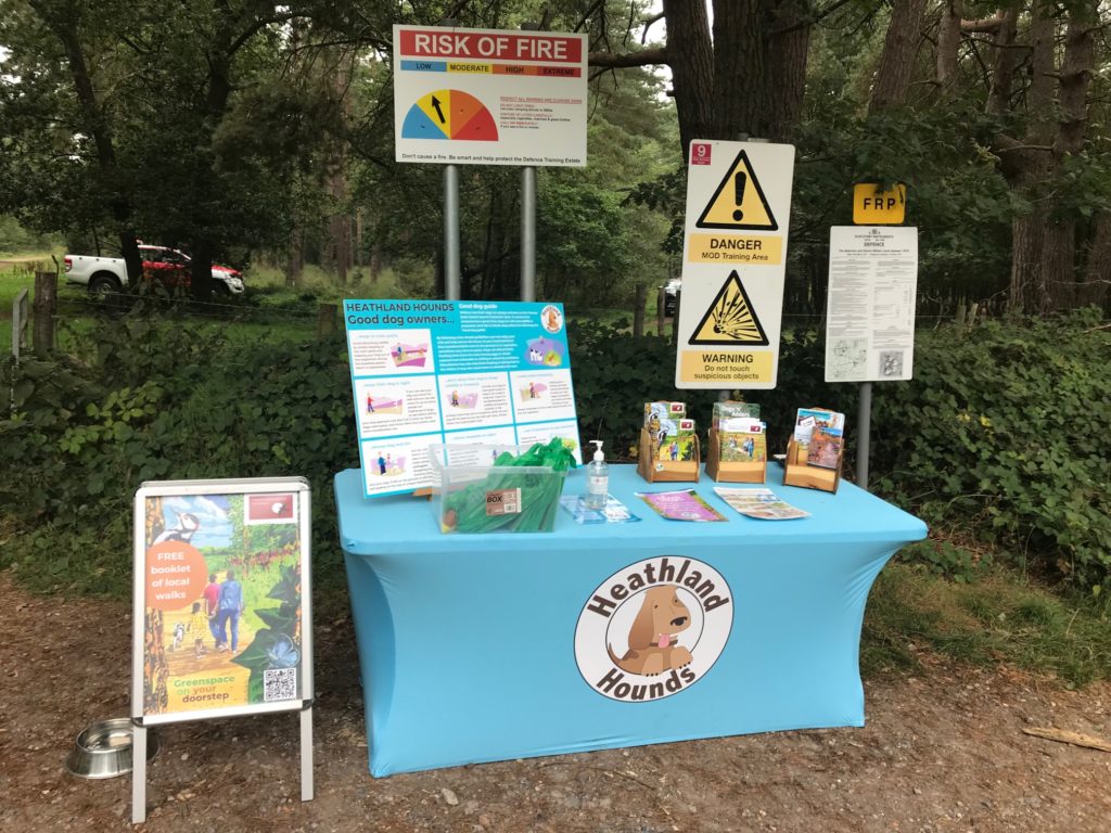 Photograph of information table showing MOD information signage with the Heathland Hounds branding