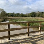 Photograph of wooden viewing platform looking out across a pond system