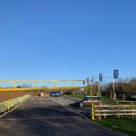 Photo of a good sized surfaced car park with yellow height barrier