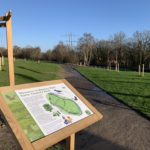 Photo of a wooden notice board with a map of the site