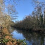 The canal in winter with two people walking along the towpath