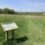 Photo of an information board and the meadow beyond