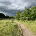 Photo of a surfaced path, with dark sky behind.