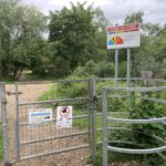 Photo of a metal gateway displaying our sign.