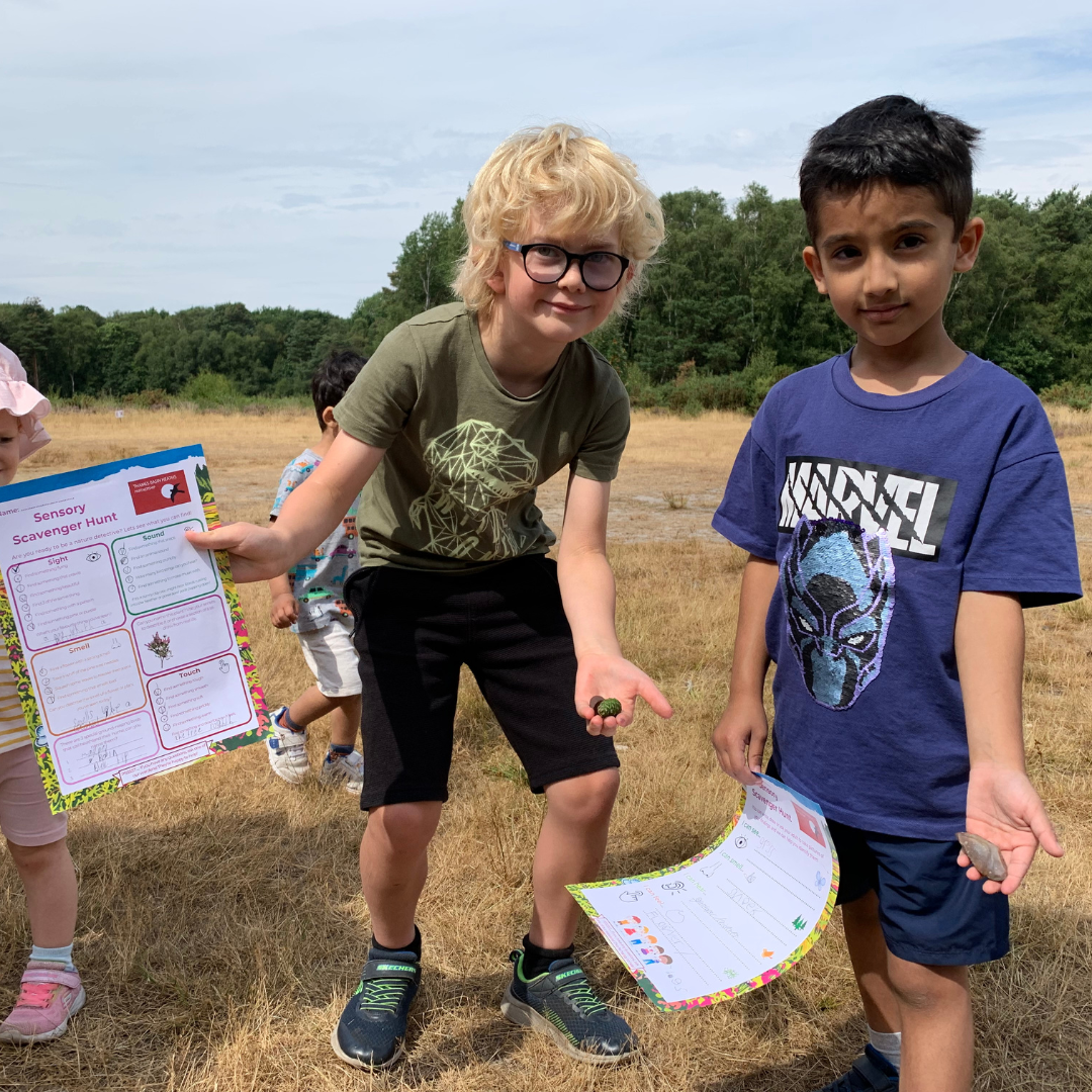 Photo of two young boys holding out the completed scavenger hunt sheets.