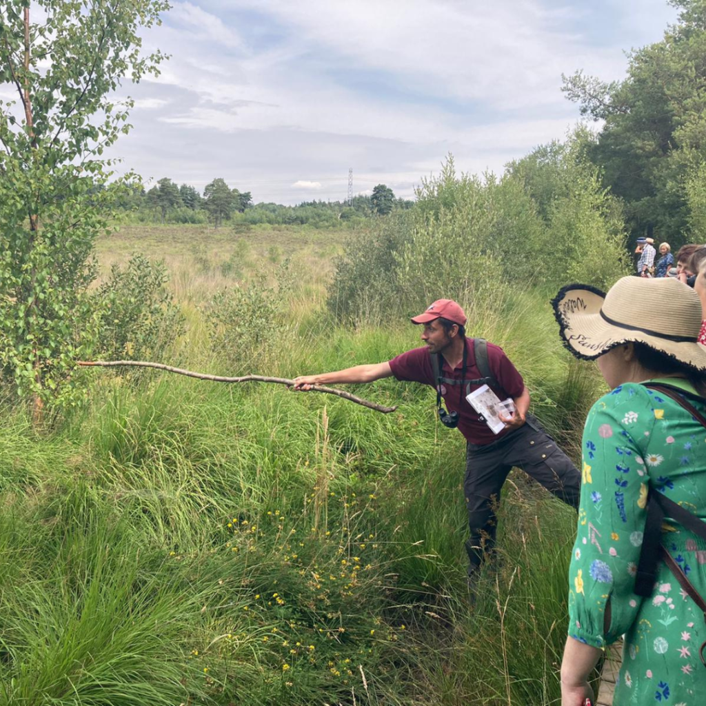 Photo of Michael pointing at something with a very long stick!