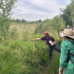 Photo of Michael pointing at something with a very long stick!