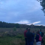 Phot of a group of people on the heath at dusk.