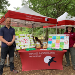 Photo of our gazebos and information boards, with two adults standing either side