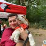 Photo of Warden Tim cuddling the dog Monty.