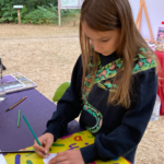 Photo of a girl wearing a sweatshirt with a large snake design on it.