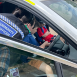 PCSO Sian from Surrey Heath Police beside a Police car, with kids inside!