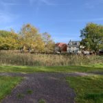 Photo of a wide gravel path with new houses behind.