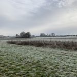 Photo os rolling meadow in winter, with light snow on the ground.