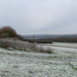 Photo os rolling meadow in winter, with light snow on the ground.