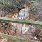 Photo of a muddy, orange stream.