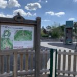 Photo of an information map and a children's playground behind it.