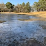 Photo of a large frozen pond that stretches across the sandy bowl of the Sand Pit.
