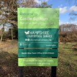 Photo of a large sign welcoming you to Castle Bottom. It asks for dogs to kept on leads because livestock are grazing.