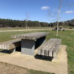 Photo of a solid looking, sturdy picnic table with benches.