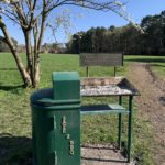 Photo of a safe BBQ area with a raised platform for cooking and a metal bin for ashes.