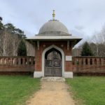 Photo of the entrance to the Peace Garden, with its ornate brick enclosing wall and wooden gates that go through an ornate archway with domed roof above.