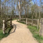 Photo of a wide surfaced path leading into woodland, a sign say "OLD OAK WAY"