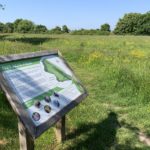 Photo of an information sign at the entrance to the meadow. Signs includes a map of the small site.