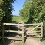 Photo of a wooden gateway between meadows.