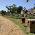 Photo showing rubbish bins in the foreground and a children's play facility in the background