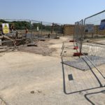 Photo of building works. There is temporary fencing marking the route to the public green space.