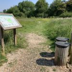 Photo of two rubbish bins and an information board.