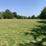 Photo of a large, open, green recreational area with short mown grass.