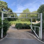 Photo of a small gravel car park with a height barrier at the entrance.