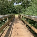 Photo of a stout wooden footbridge over the river.