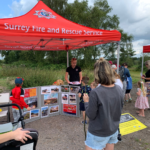 Photo of people around a gazebo with a red banner saying "Surrey Fire and Rescue Service".