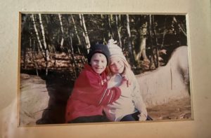 Photograph of Senior Warden Zoe and her brother as young children sitting on a bench