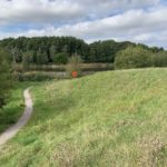 Photo showing a narrow surfaced path winding around a pretty lake.