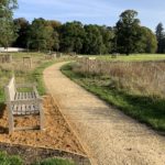 Photo of a bench looking out across a pleasant landscaped parkland