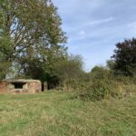 Photo of a brick pillbox nestled in the side of a hill.