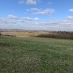 Photo taken on a wintery hillside, looking out over the surrounding countryside.