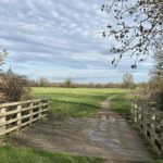 Photo of a bridge that takes a footpath into an open field