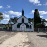 Photograph of fenced-off historic church made from corrugated iron